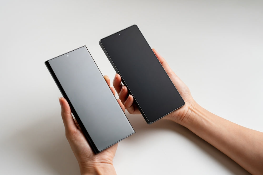 A refurbished Samsung Galaxy S25 next to another Samsung Galaxy phone being held in a hand, as if comparing.